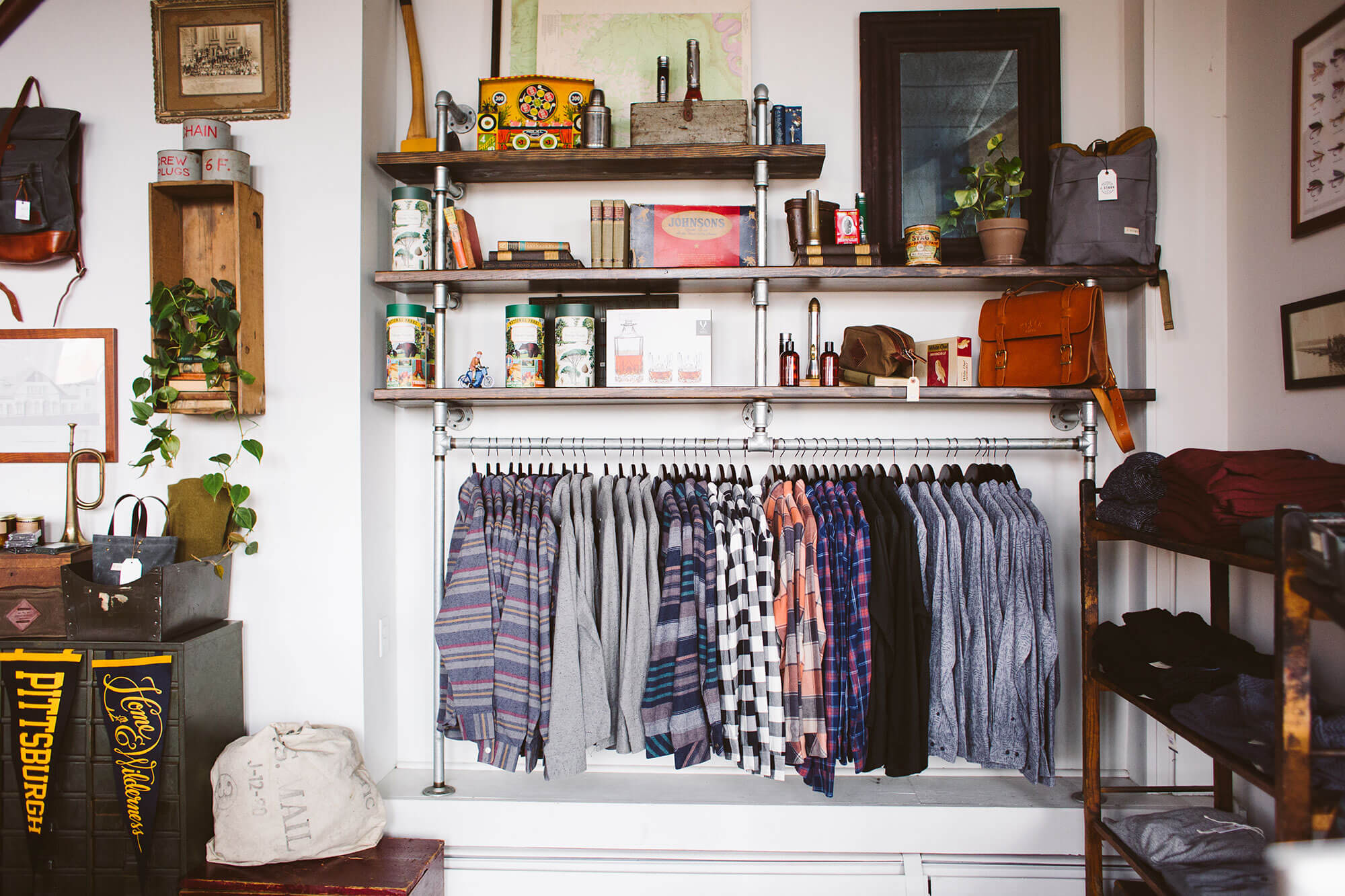 A product wall at Ellicott & Co feature clothing, antiques, outdoor goods, and vintage bags